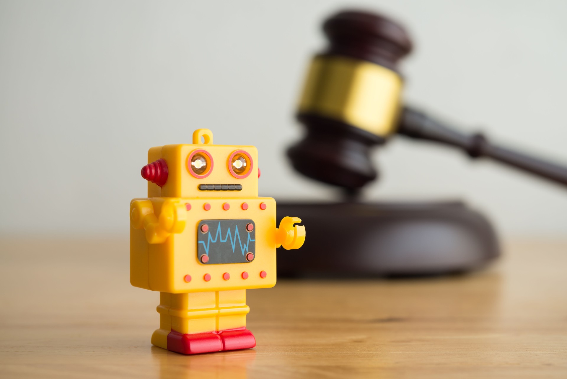 AI artificial intelligence bot and hammer judge gavel on wooden table with white wall background.